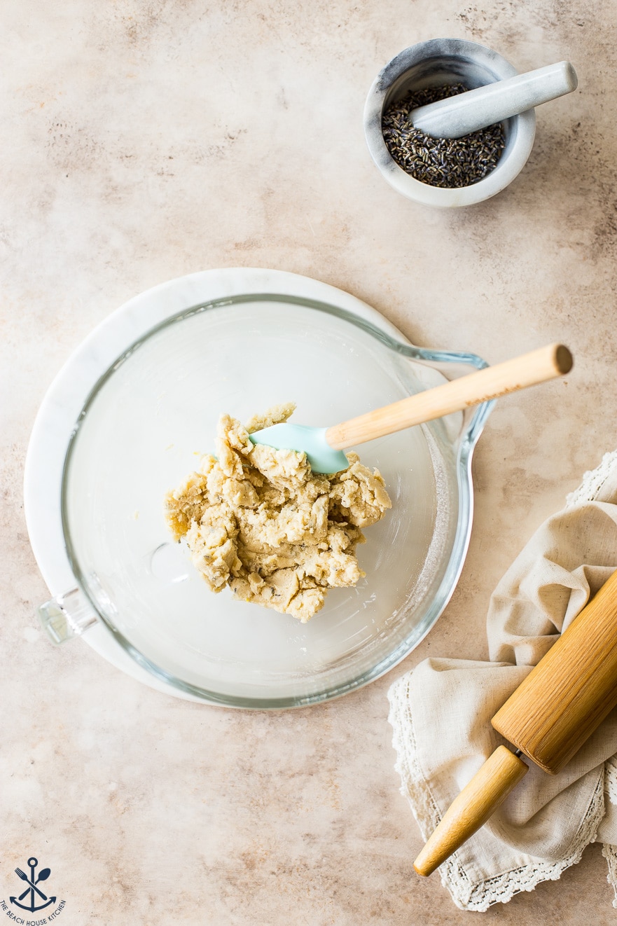 Overhead photo of cookie dough in a glass bowl with a spatula
