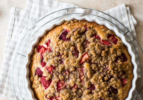Up close overhead photo of a strawberry buckle in a round white baking dish.