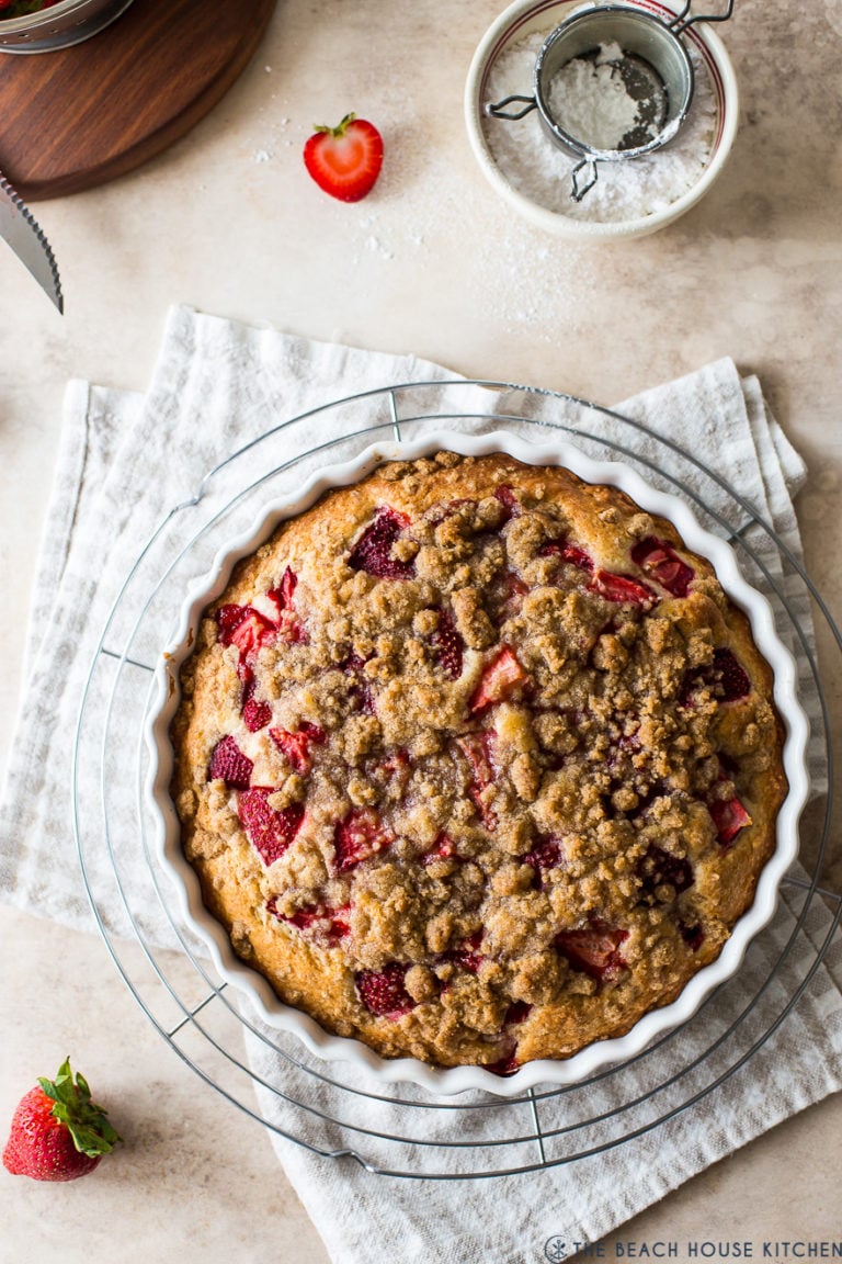 Up close overhead photo of a strawberry buckle in a round white baking dish.