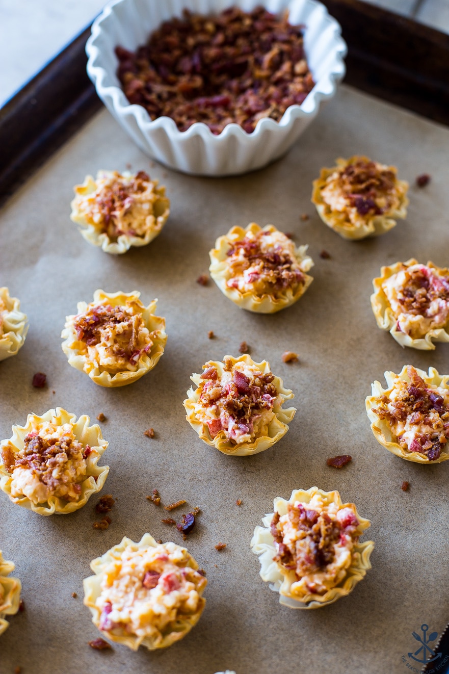 Pre-baked Pimento Cheese Bites with bacon on a parchment lined baking sheet