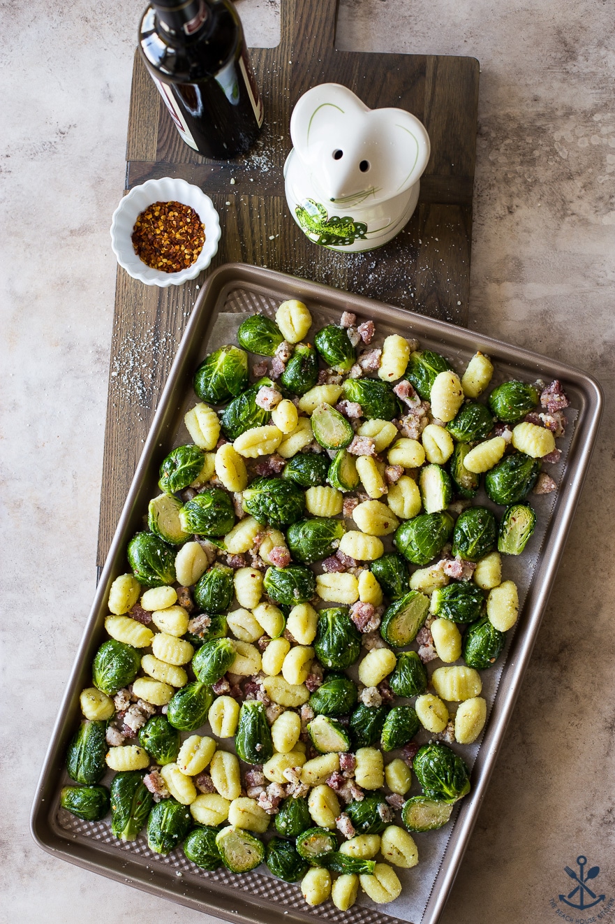 Pre-baked Gnocchi with veggies and pancetta on a baking sheet