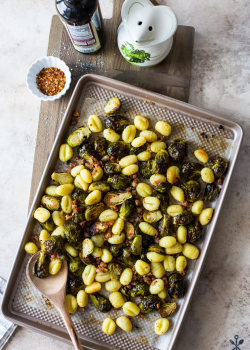 Overhead photo of a sheet pan meal with brussels sprouts, gnocchi and pancetta