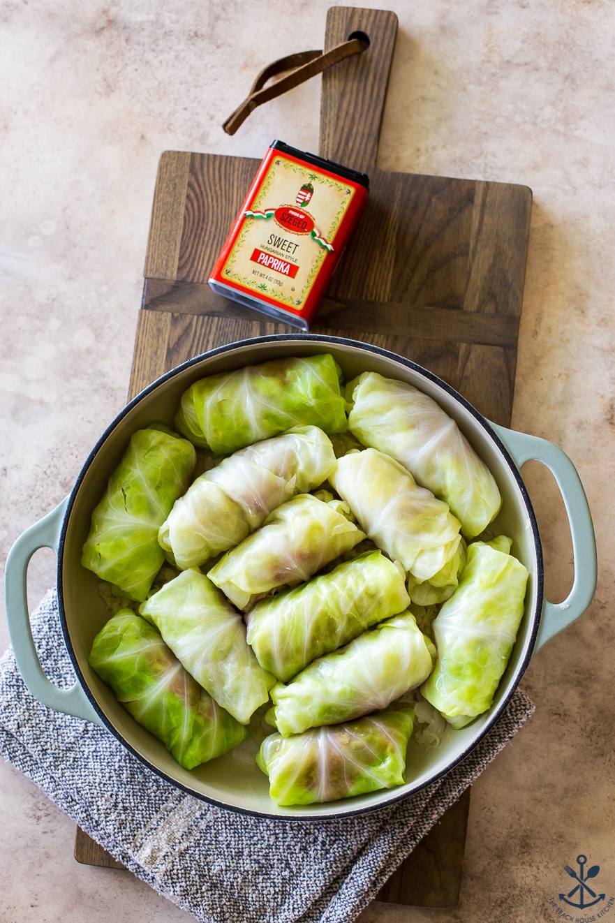 Overhead photo of cabbage rolls in a baking dish with a box of paprika off to the side