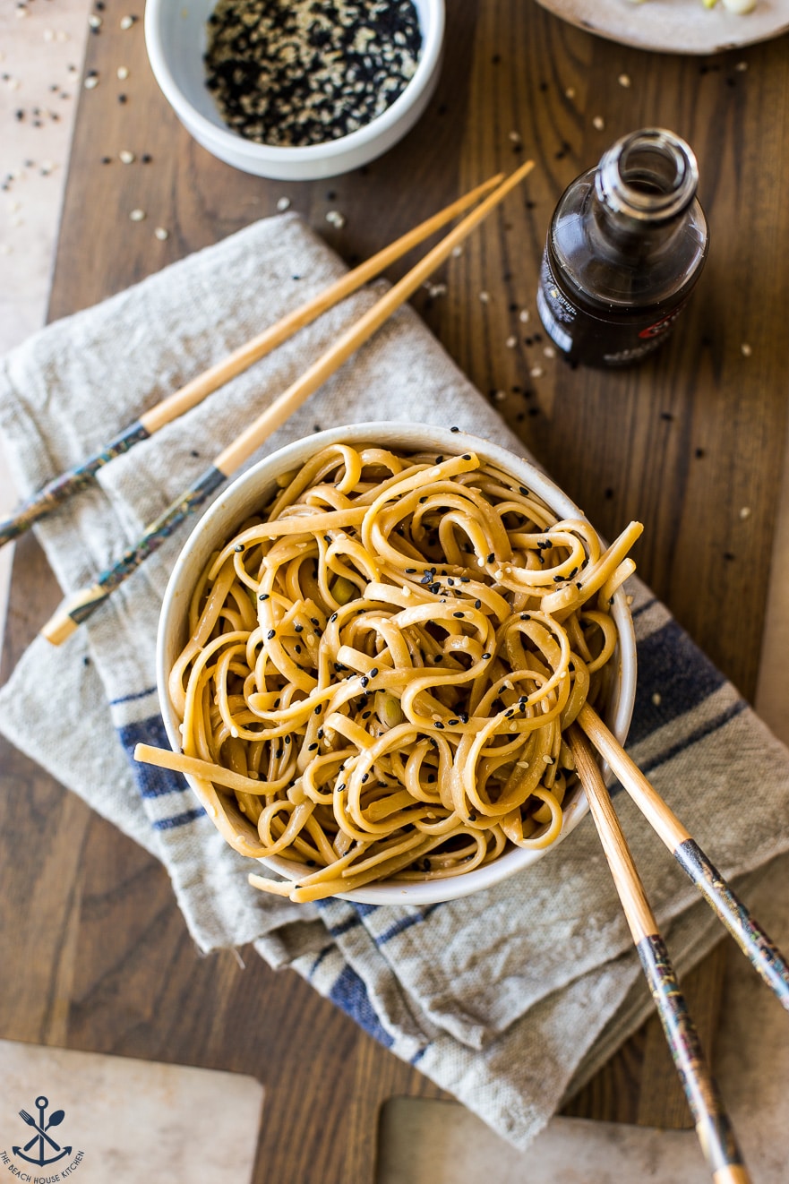 Overhead photo of a small bowl of sesame noodles with chopsticks