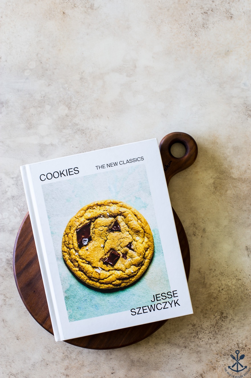 Cookies cookbook on a dark wood round cutting board