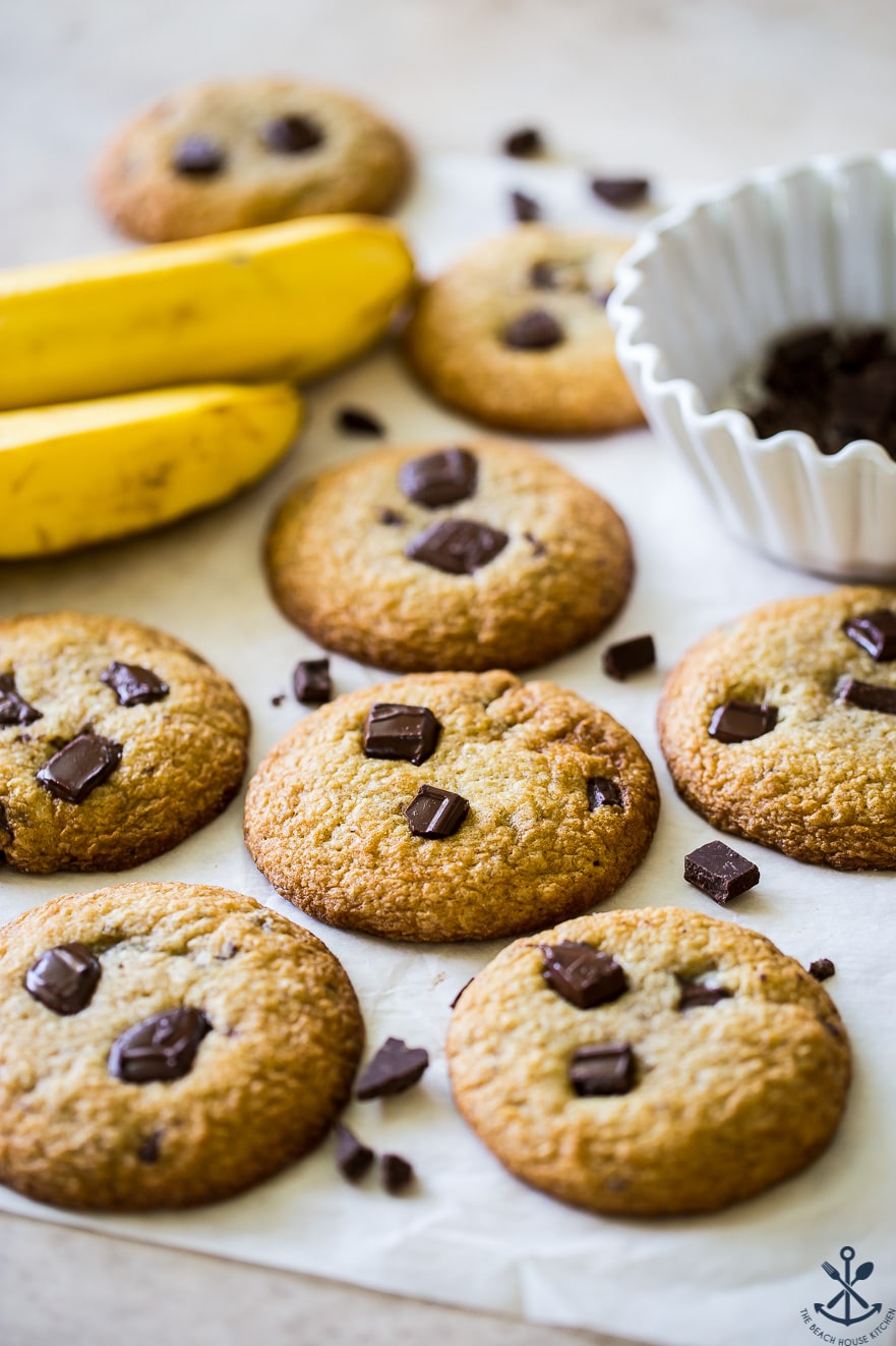 Chocolate chunk cookies with two bananas and a bowl of chocolate chunks in the background