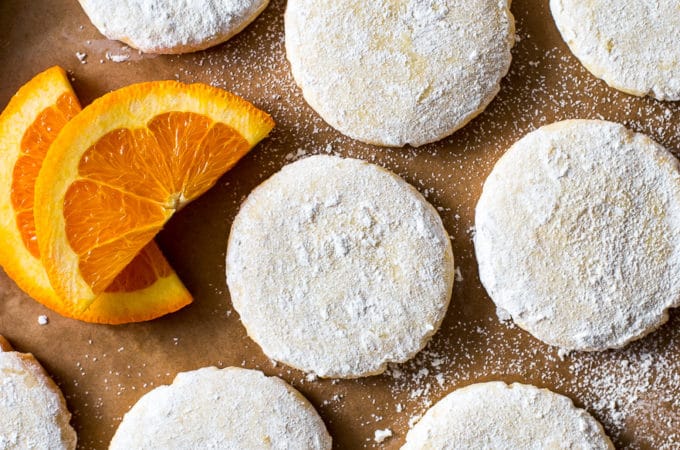 Overhead photo of a tray of citrus meltaway cookies and some orange and lemon slices