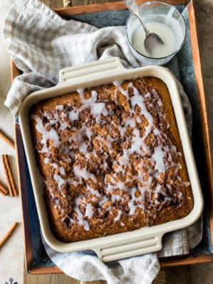 Overhead photo of a glazed cinnamon cake in a square baking dish