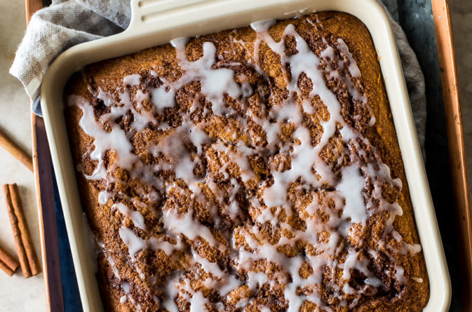 Overhead photo of a glazed cinnamon cake in a square baking dish