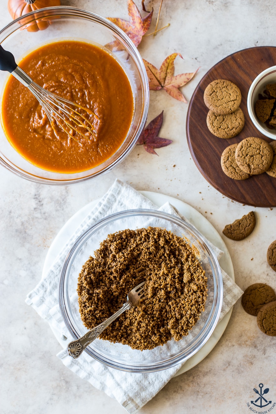 Overhead photo of two bowls, one filled with pumpkin mixture and the other filled with gingersnap crust crumbs