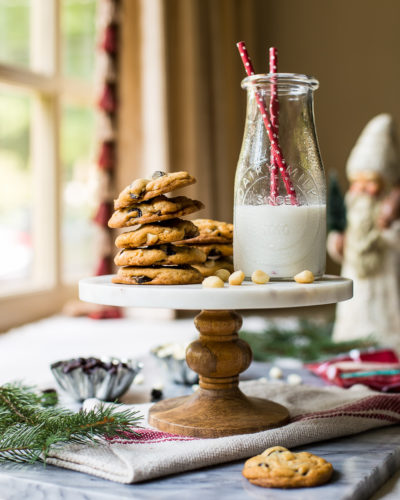 A cake stand topped with cookies and a bottle of milk