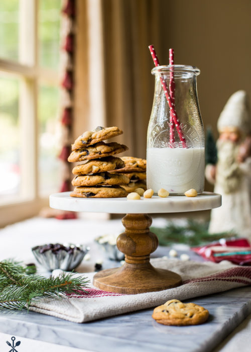 A cake stand topped with cookies and a bottle of milk