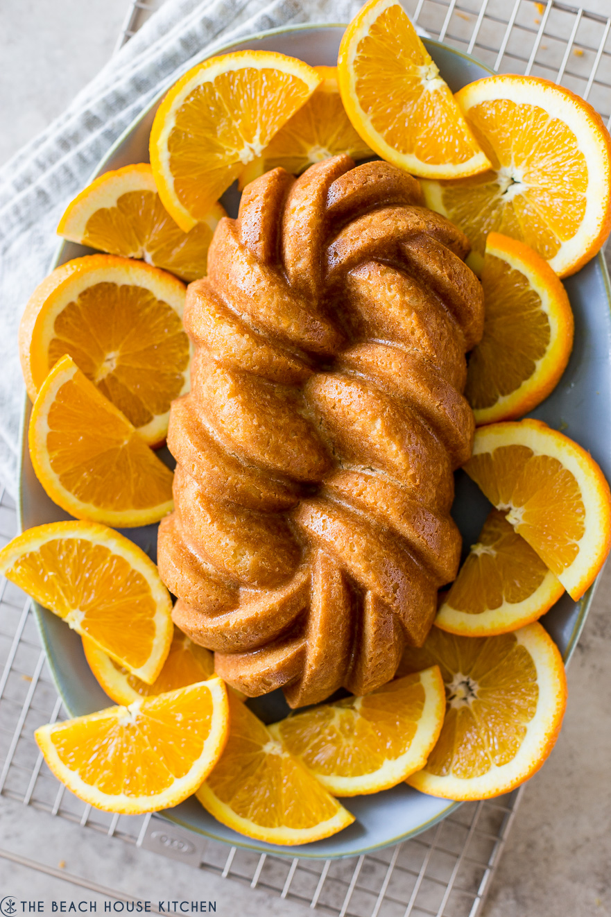 Up close overhead photo of a loaf cake surrounded by orange slices