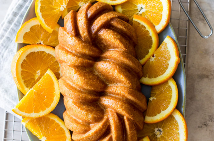 Overhead photo of an orange loaf cake surrounded by orange slices