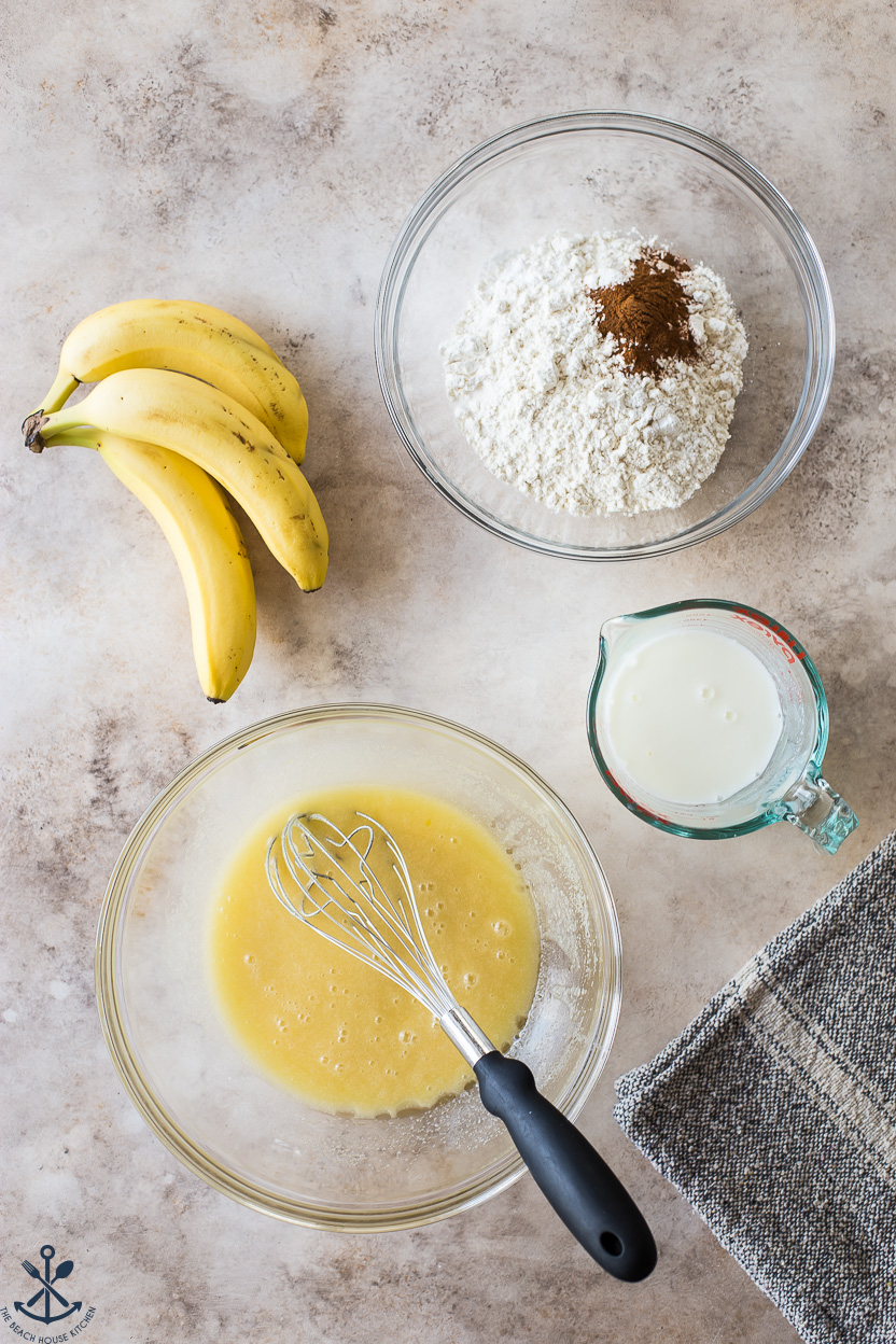 Overhead photo of two bowls, measuring cup and three bananas