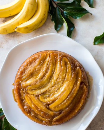 Overhead photo of a banana upside-down cake on a white platter