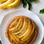 Overhead photo of banana upside-down cake on a white platter