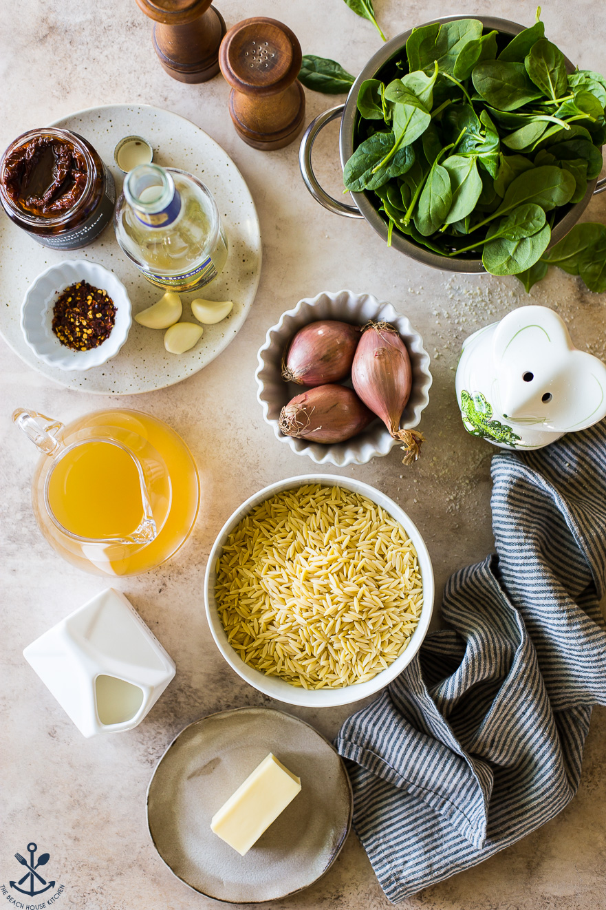 Overhead photo of ingredients in bowls for orzo pasta and spinach dish