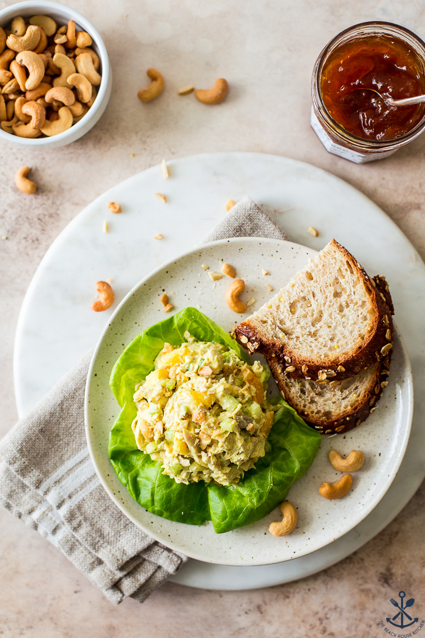 Overhead photo of a plate with chicken salad on a piece of lettuce with two slices of bread