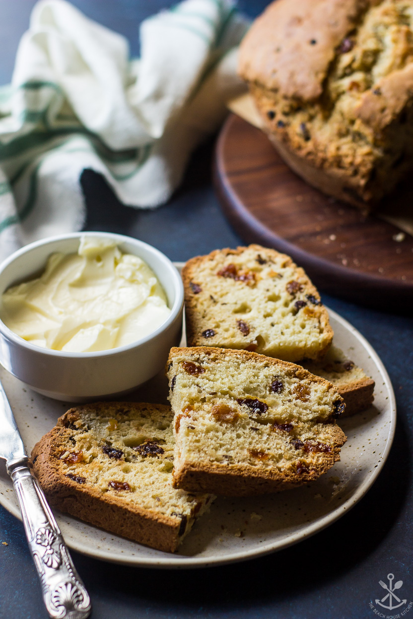 A plate with slices of bread with raisins and a bowl of butter