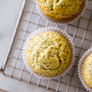 Up close overhead photo of lemon poppy seed muffins on a gold wire rack