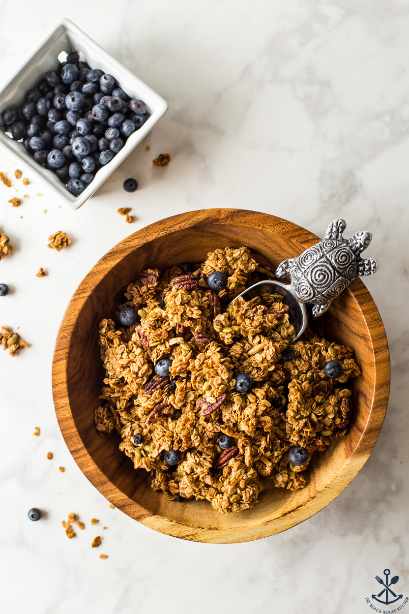 Overhead photo of a bowl of granola and a carton of blueberries