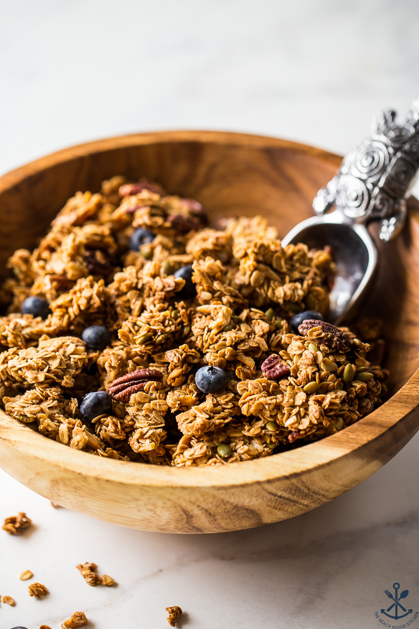 Up close photo of a wooden bowl of granola with blueberries