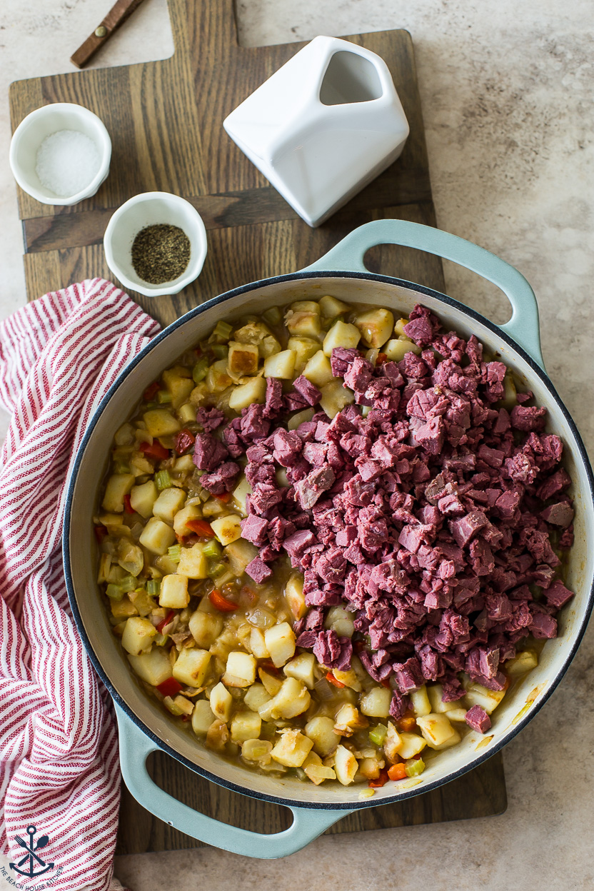Overhead photo of a skillet of cubed potatoes and veggies topped with cubed corned beef