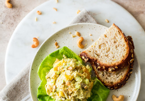 Overhead photo of a plate of curried chicken salad and slice of bread