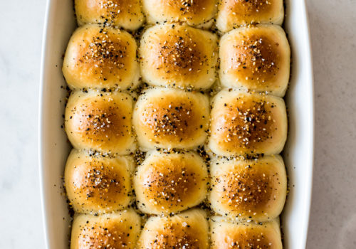 Overhead photo of a baking dish of soft everything dinner rolls