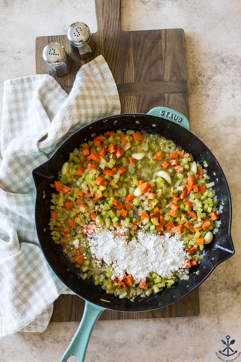 Overhead photo of a skillet of cooked veggies topped with some all-purpose flour