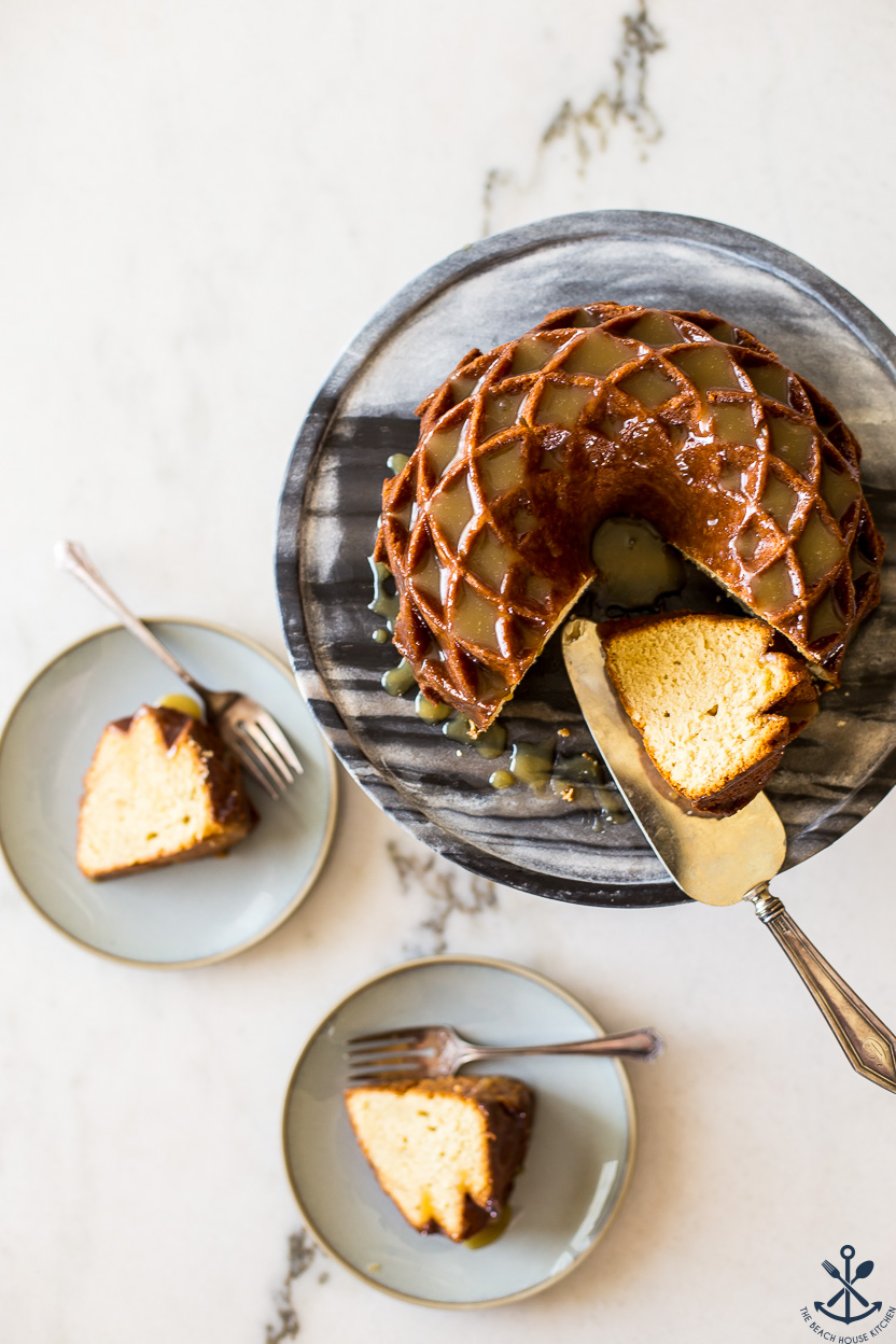 Overhead photo of a bundt cake on a cake stand with two plates of cake slices