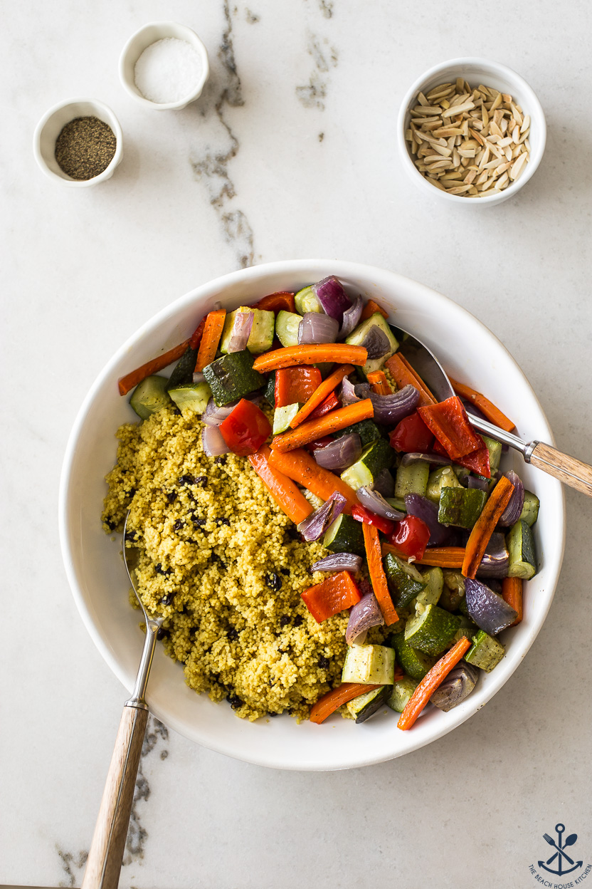 Overhead photo of a round dish of cooked couscous and roasted vegetables