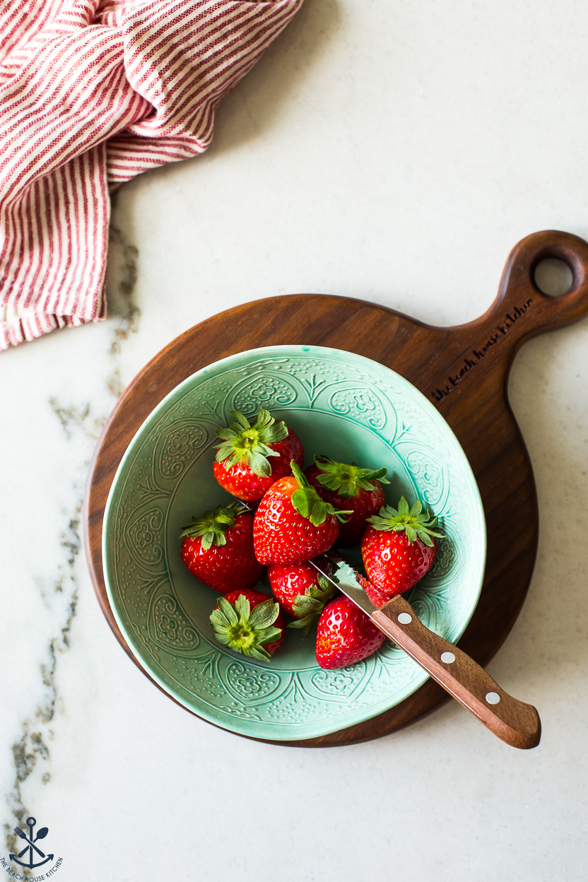 Overhead photo of a green bowl of strawberries