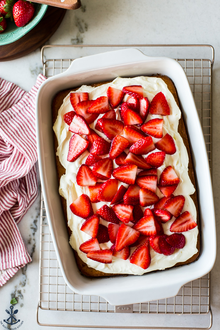Overhead photo of a simple strawberry cake topped with sliced strawberries