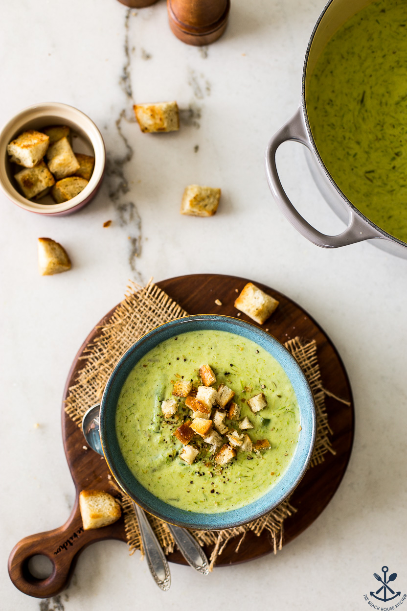 Overhead photo of a bowl of smoky asparagus soup in a bowl and a small bowl of croutons