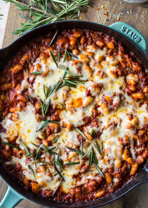 Overhead photo of a skillet of Italian Baked Beans topped with Cheese