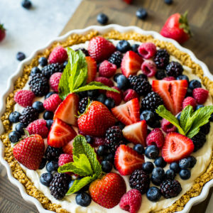 Overhead photo of a fresh berry tart on a wooden board