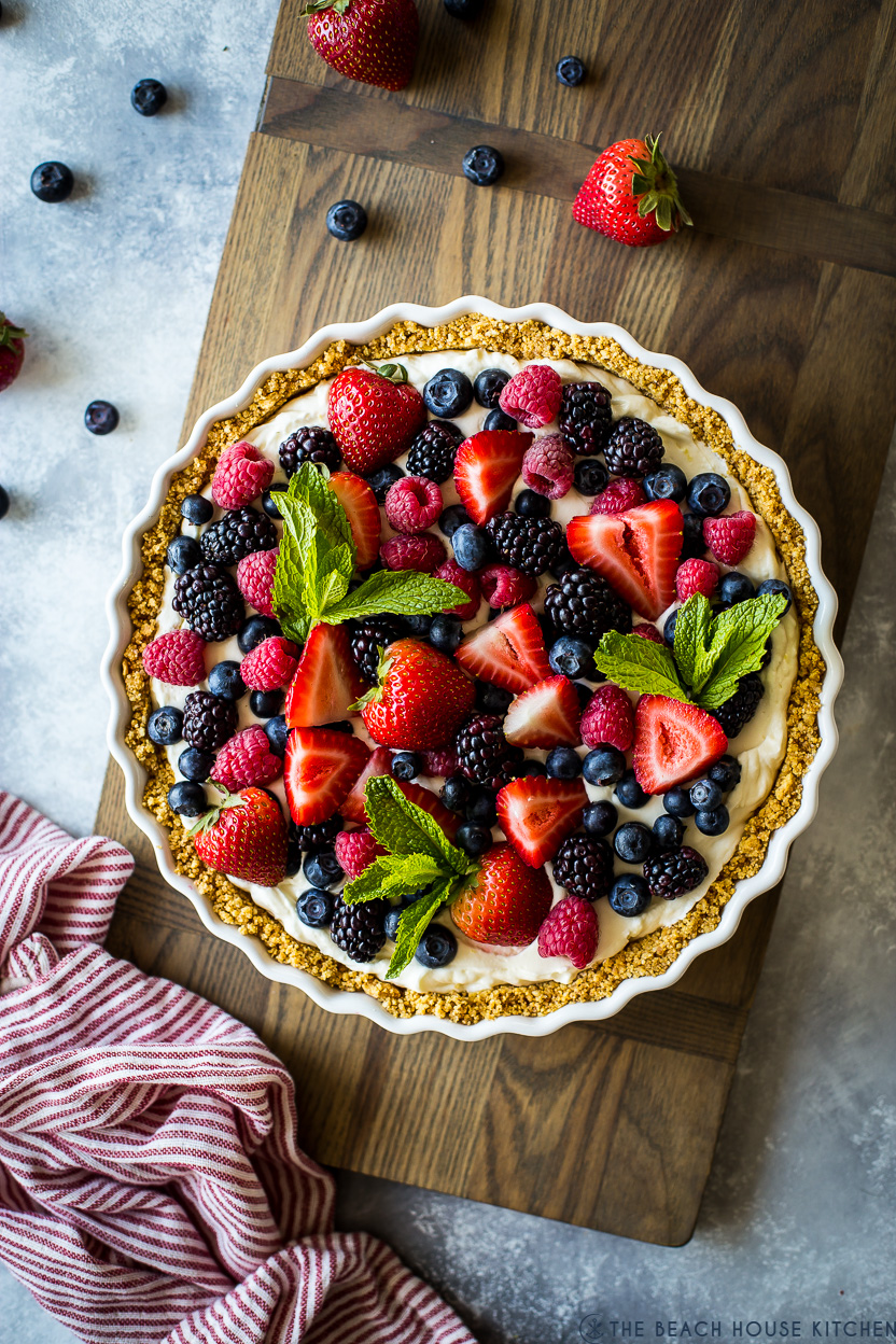 Overhead photo of a berry tart on a wooden board