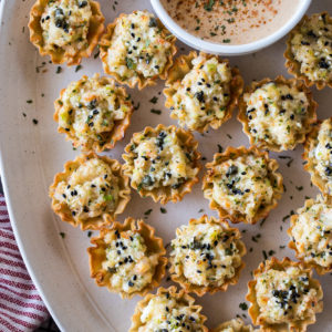 Up close over head photo of shrimp toast cups on an oval platter