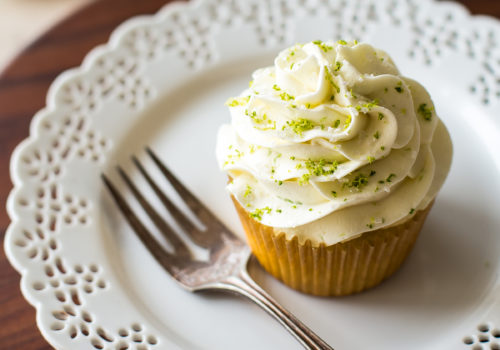 A margarita cupcake on a white plate with a fork
