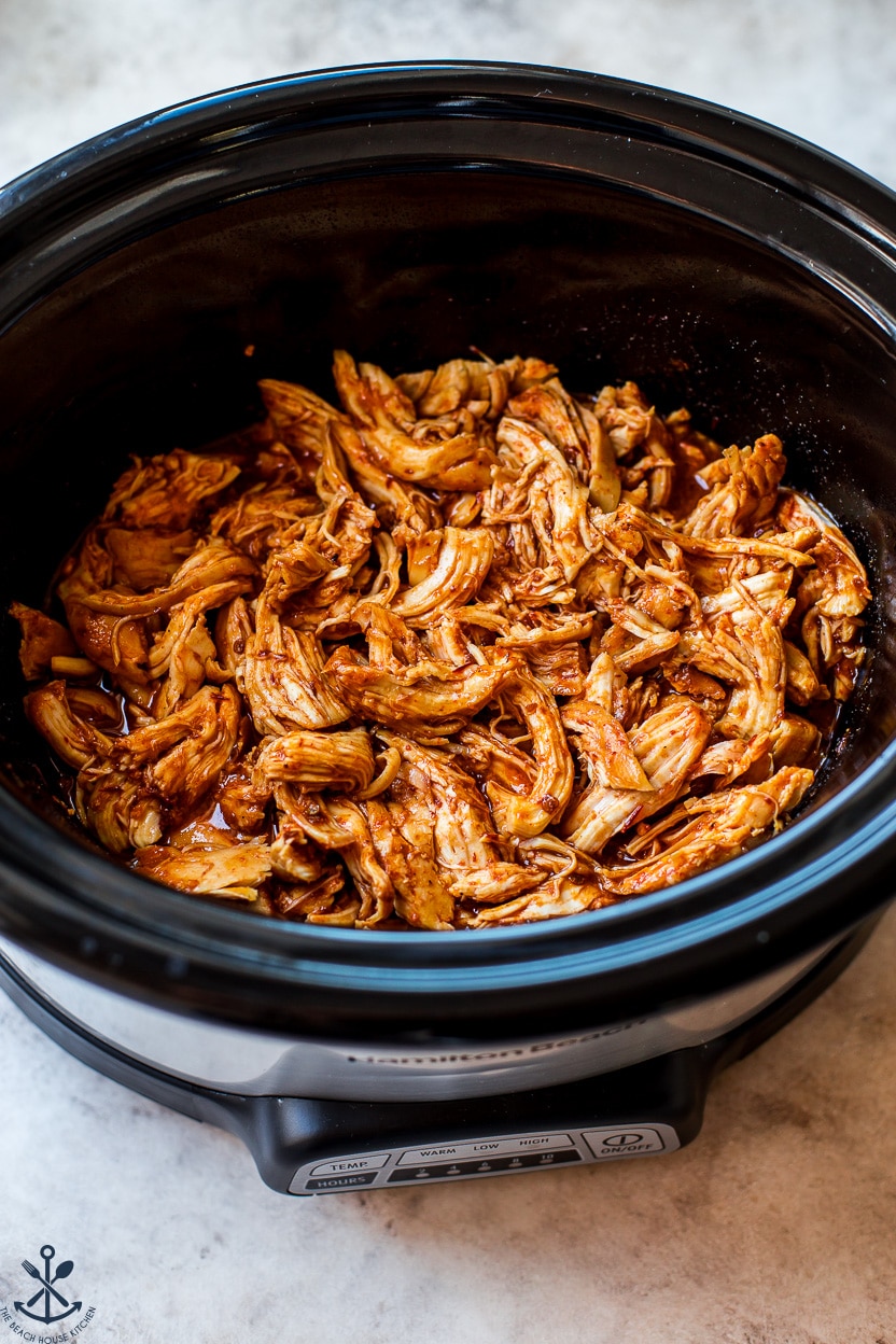 Overhead photo of shredded honey chipotle chicken in a slow cooker