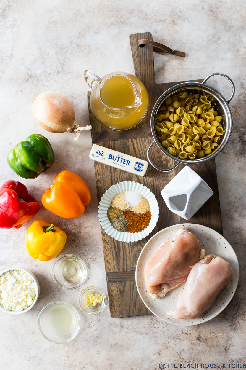 Overhead photo of ingredients for chicken fajita pasta on a wooden board
