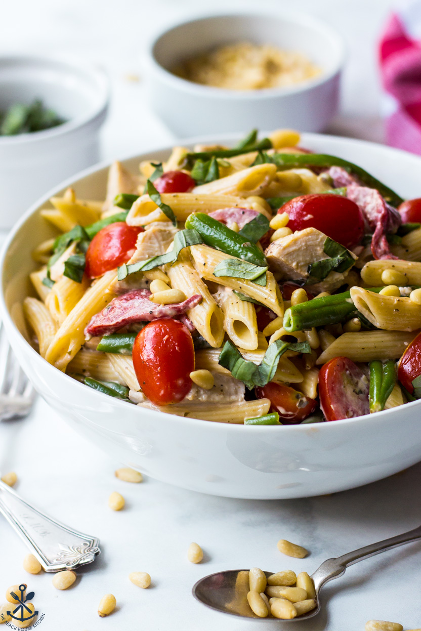 Up close photo of a bowl of pasta salad with chicken and tomatoes