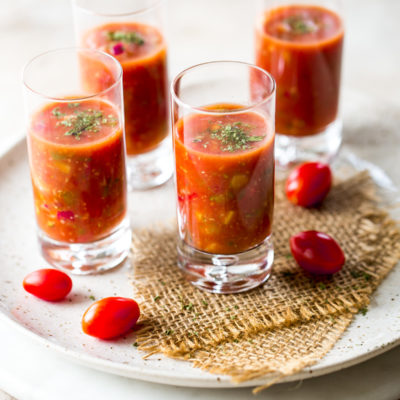 Shooters of gazpacho on a round marble board