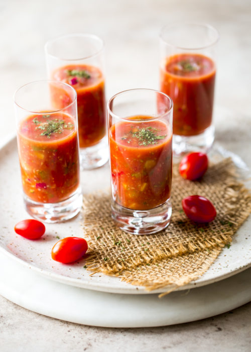 Shooters of gazpacho on a round marble board