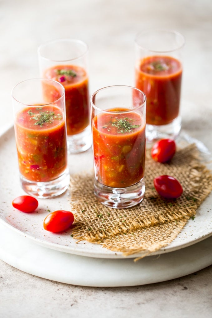 Shooters of gazpacho on a round marble board