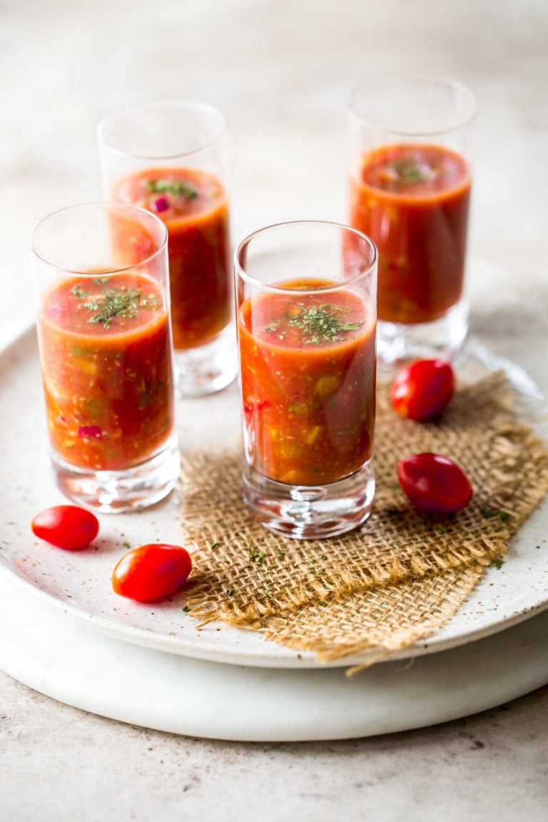 Shooters of gazpacho on a round marble board