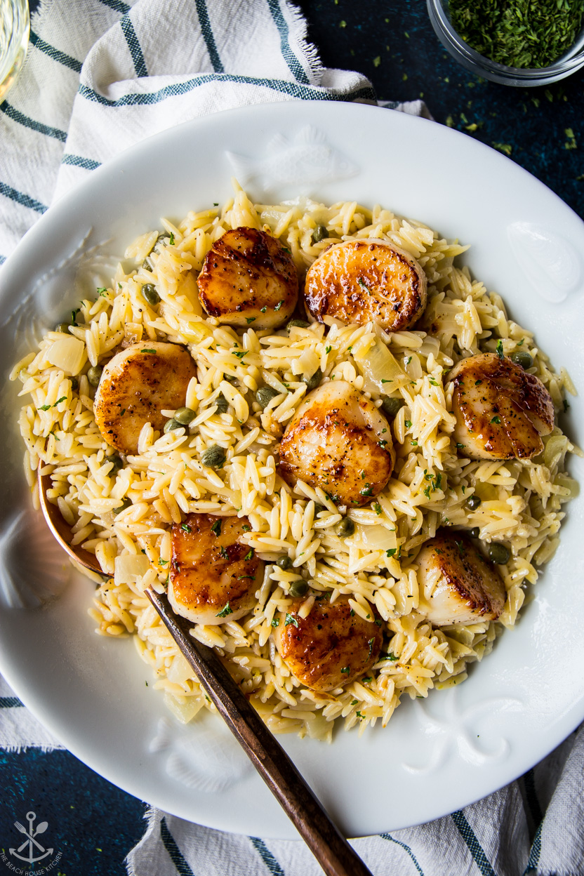 Up close overhead photo of Pan Seared Scallops with Orzo Piccata in a white bowl