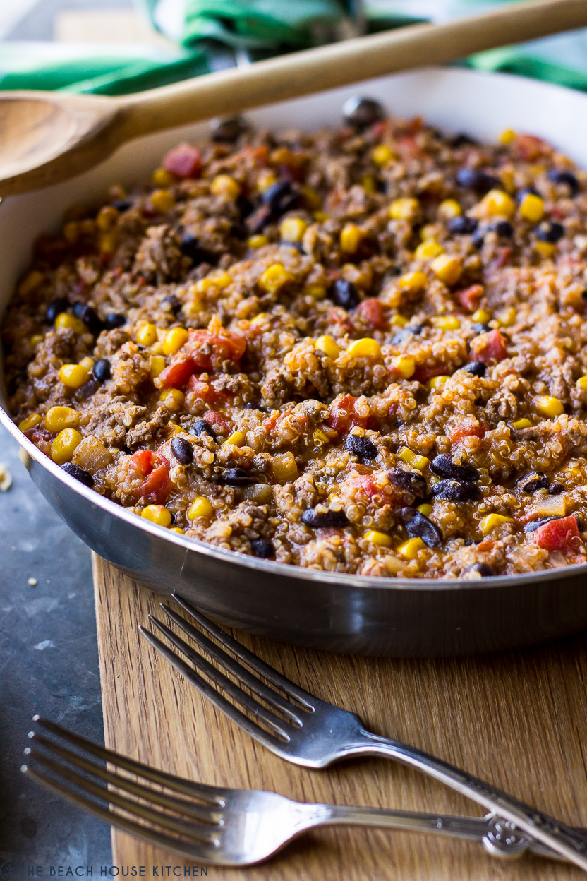 Up close photo of a beef and quinoa mixture in a skillet with two forks
